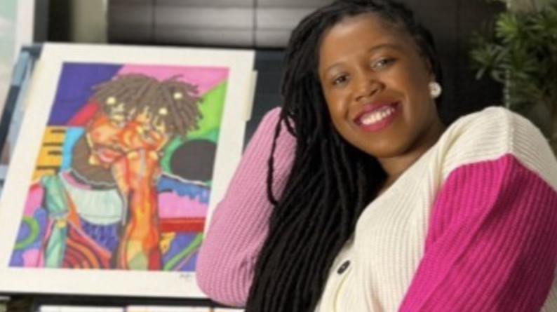 Domonique Brown sitting next to one of her pieces of framed art