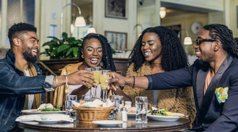 Black men and women making a toast around a table