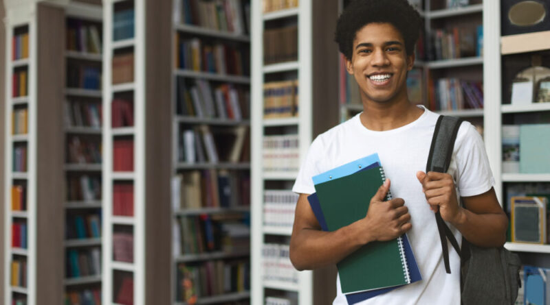 Student posing on bookshelves background